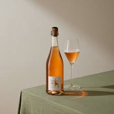 Oddbird Orange wine bottle and glass on green table cloth