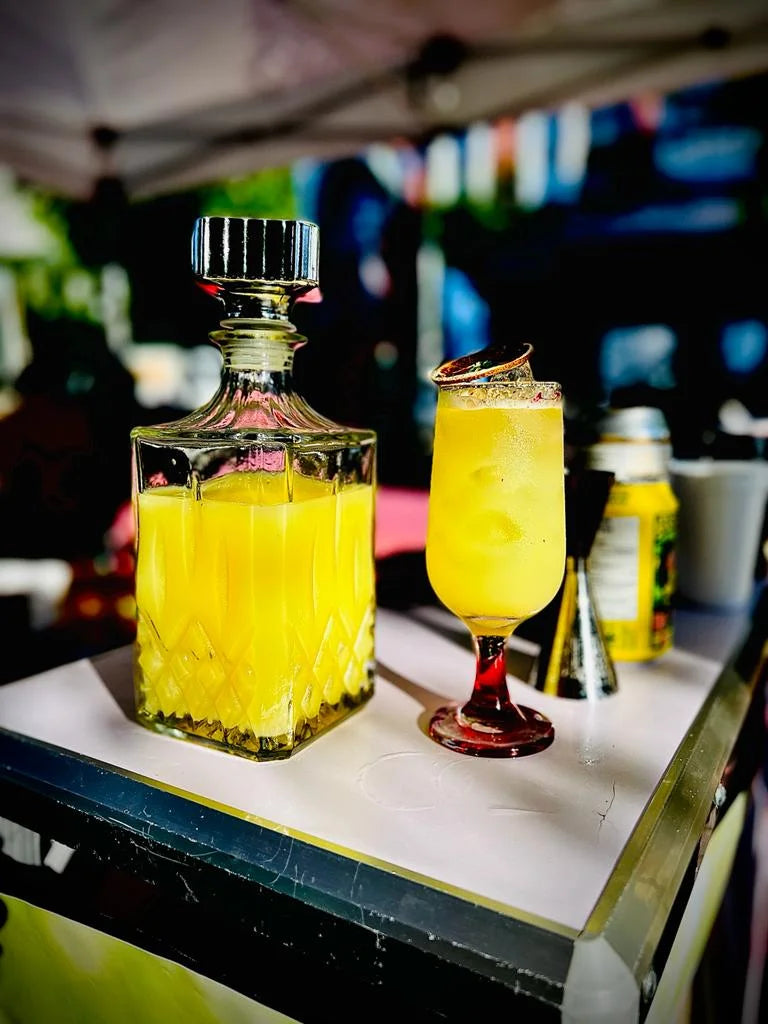 A bottle of ZERO Spicy Ginger beverage placed next to a filled glass on a table, with a bar setting in the background.