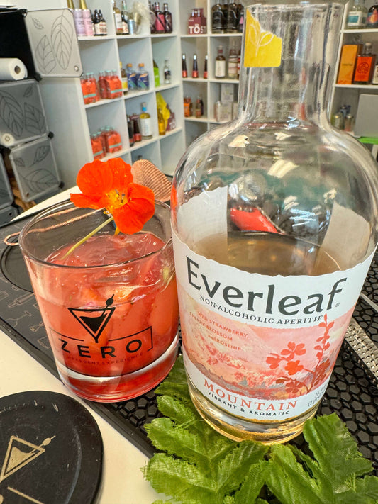 Everleaf Mountain non alcoholic bottle and glass with cocktail garnish with flower in the background is non alcoholic bottle shop